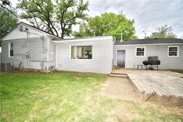 5233 N Garfield Ave, Kansas City, MO 64118 - back of house featuring a wooden deck, a lawn, and cooling unit