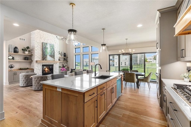 2314 SW Serena Pl, Lees Summit, MO 64082 - kitchen featuring a chandelier, custom exhaust hood, appliances with stainless steel finishes, light wood finished floors, and an island with sink