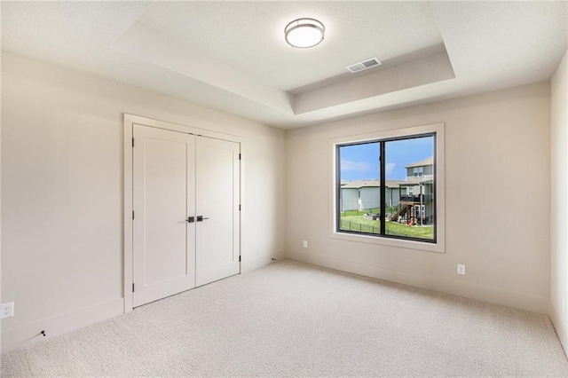 2314 SW Serena Pl, Lees Summit, MO 64082 - unfurnished bedroom featuring a tray ceiling, carpet flooring, and a closet