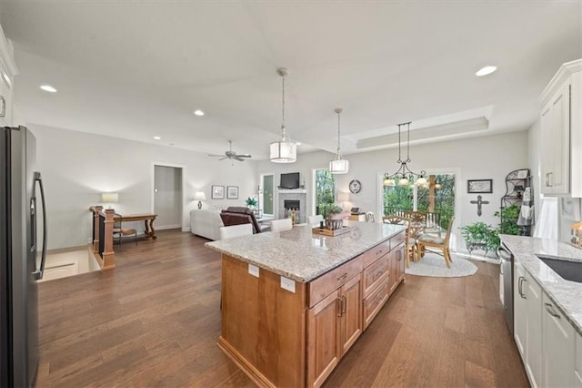 811 W Shawhan Pkwy, Lees Summit, MO 64086 - kitchen featuring light stone counters, dark wood finished floors, ceiling fan, a fireplace, and appliances with stainless steel finishes