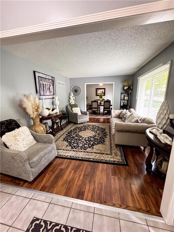 4024 NE 59th Ter, Gladstone, MO 64119 - living area featuring a textured ceiling, tile patterned floors, and visible vents
