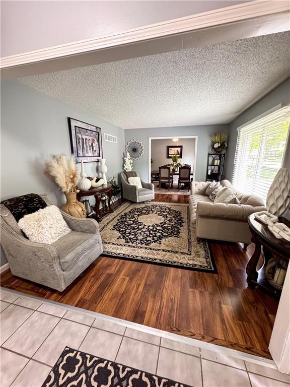 4024 NE 59th Ter, Gladstone, MO 64119 - living room with tile patterned floors, a textured ceiling, and visible vents