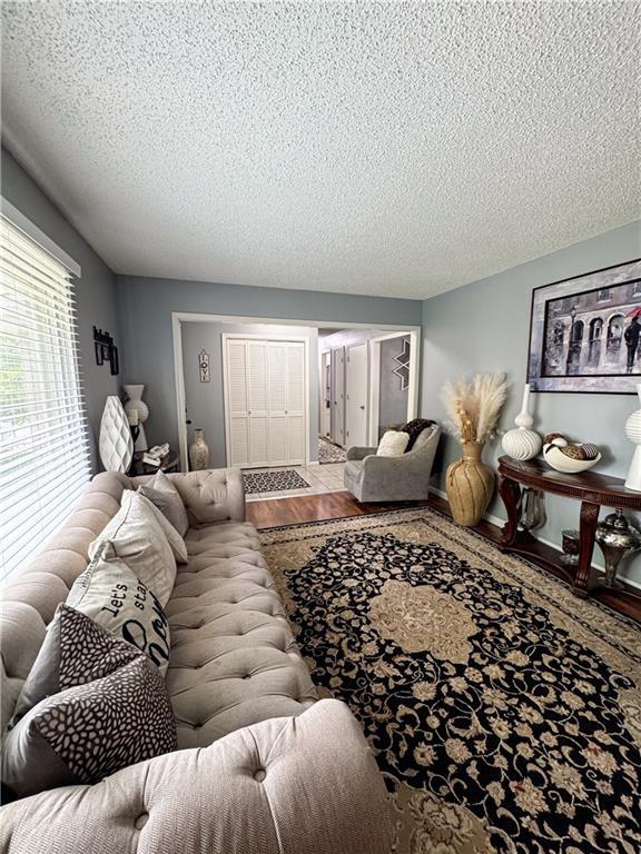 4024 NE 59th Ter, Gladstone, MO 64119 - living room with a textured ceiling and wood finished floors