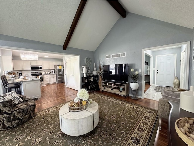 4024 NE 59th Ter, Gladstone, MO 64119 - living area with high vaulted ceiling, beamed ceiling, wood finished floors, and visible vents