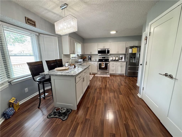 4024 NE 59th Ter, Gladstone, MO 64119 - kitchen with white cabinets, stainless steel appliances, dark wood-style floors, and plenty of natural light