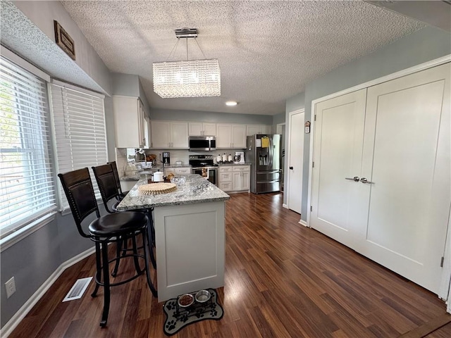 4024 NE 59th Ter, Gladstone, MO 64119 - kitchen with stainless steel appliances, dark wood-type flooring, a textured ceiling, and visible vents