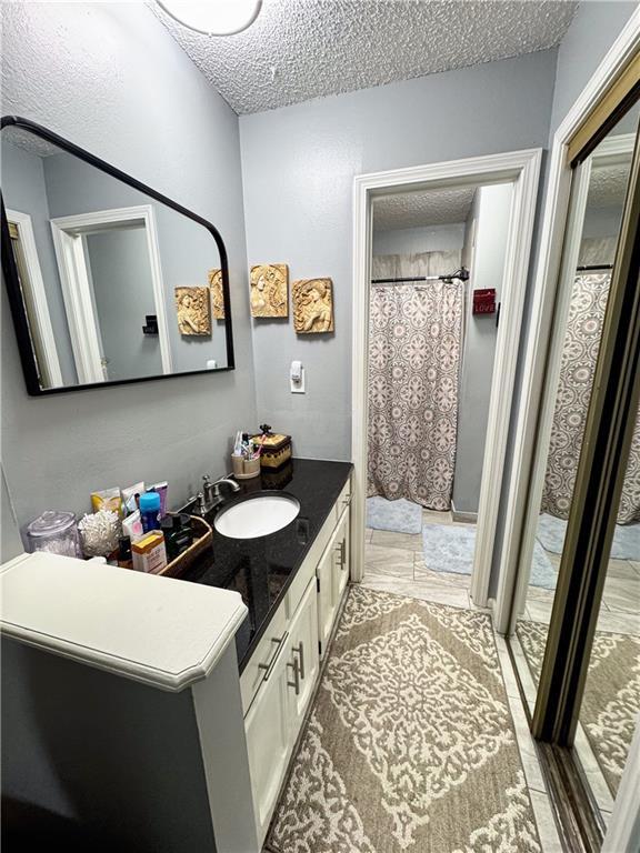 4024 NE 59th Ter, Gladstone, MO 64119 - bathroom featuring vanity, a shower with curtain, and a textured ceiling