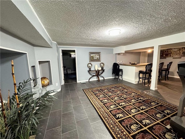 4024 NE 59th Ter, Gladstone, MO 64119 - foyer featuring dark tile patterned floors, a textured ceiling, and baseboards