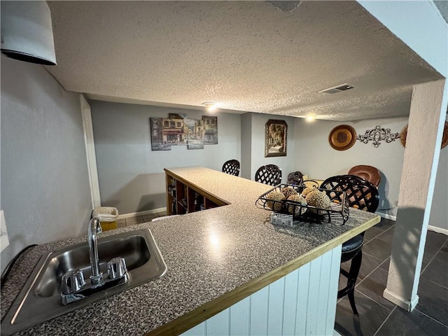 4024 NE 59th Ter, Gladstone, MO 64119 - bar with a sink, a textured ceiling, baseboards, dark tile patterned flooring, and visible vents