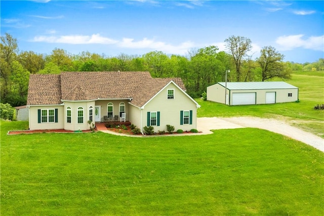 rear view of house featuring an outdoor structure, a garage, dirt driveway, a lawn, and a porch