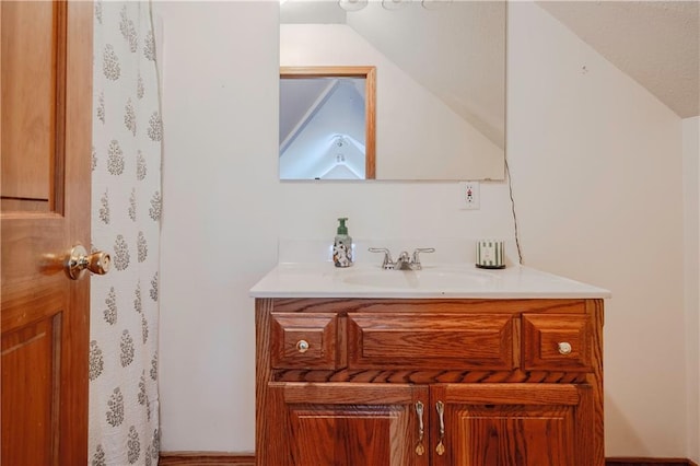bathroom featuring vaulted ceiling and vanity