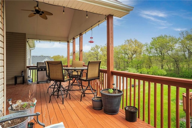 deck featuring a lawn, outdoor dining space, and ceiling fan