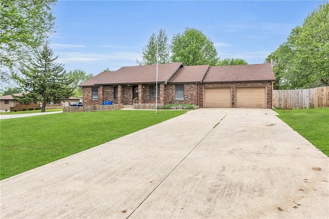 single story home with an attached garage, fence, driveway, and a front lawn