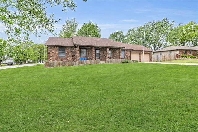 view of front of property with an attached garage, fence, and a front yard