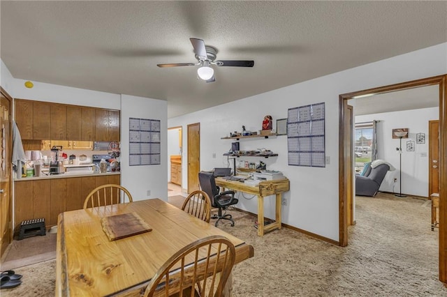 dining room featuring light colored carpet, a textured ceiling, ceiling fan, and baseboards