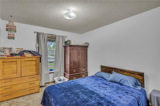 bedroom with light colored carpet and a textured ceiling