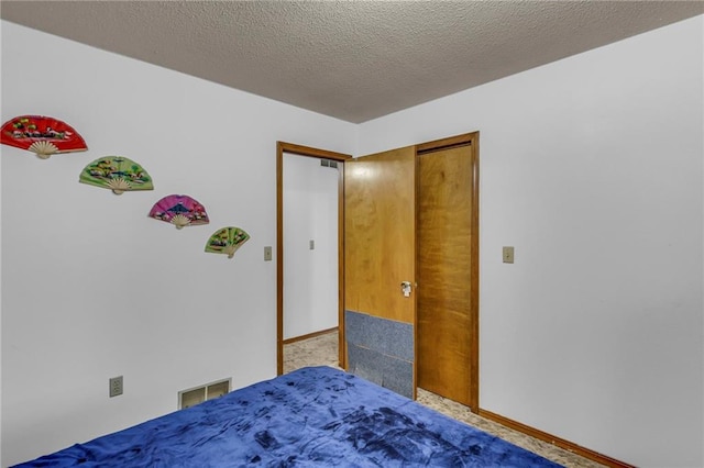 carpeted bedroom featuring baseboards, a textured ceiling, and visible vents