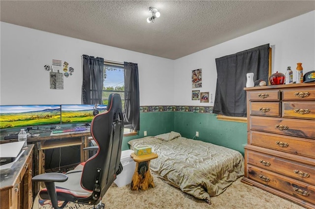 bedroom featuring carpet floors, wainscoting, and a textured ceiling