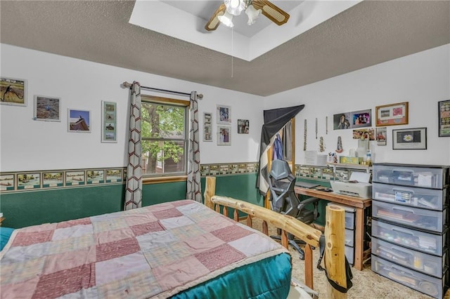 bedroom featuring carpet, a ceiling fan, and a textured ceiling