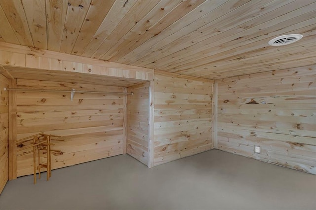 interior space featuring wood walls, visible vents, concrete floors, and wood ceiling