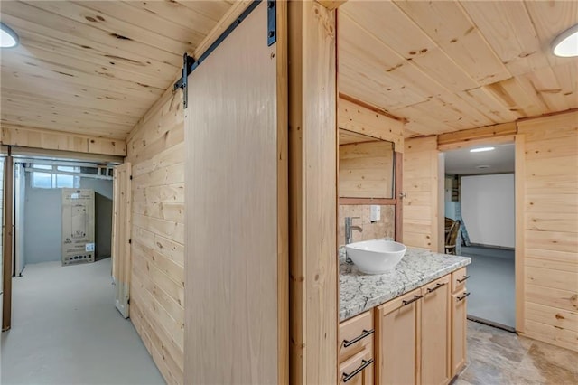 hallway featuring a sink, wooden ceiling, and wood walls
