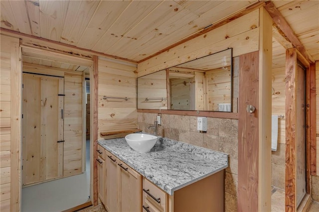 bathroom featuring wooden walls, wood ceiling, and vanity