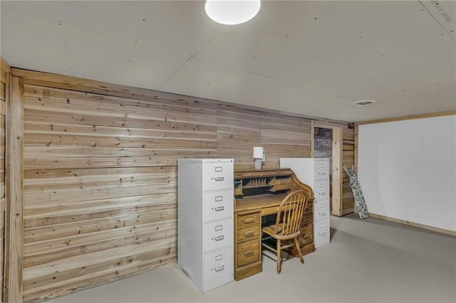office area with wooden walls and concrete floors
