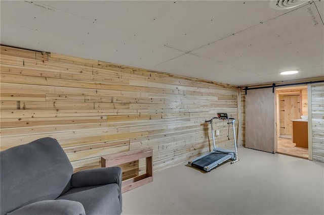 exercise area with wooden walls and a barn door