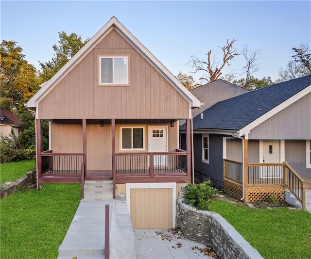 view of front of property with a porch, a front yard, and roof with shingles