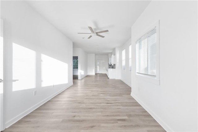 hallway featuring baseboards and light wood-type flooring