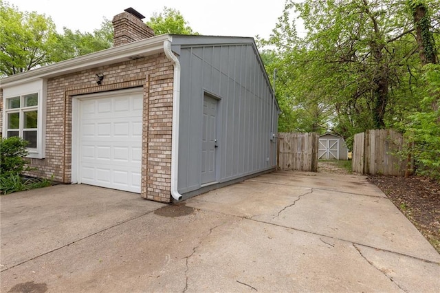 garage featuring fence and driveway