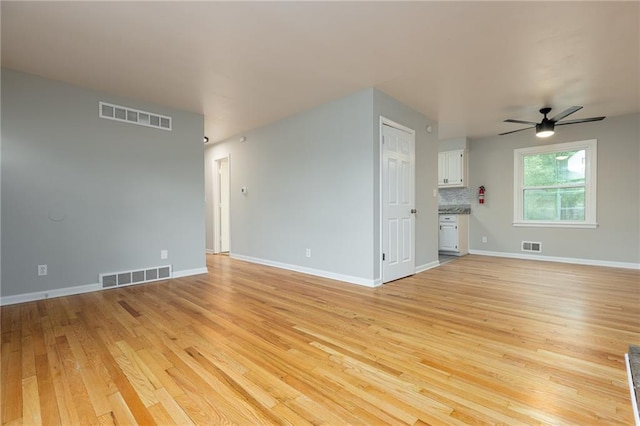 unfurnished living room with light wood-style floors, a ceiling fan, and visible vents