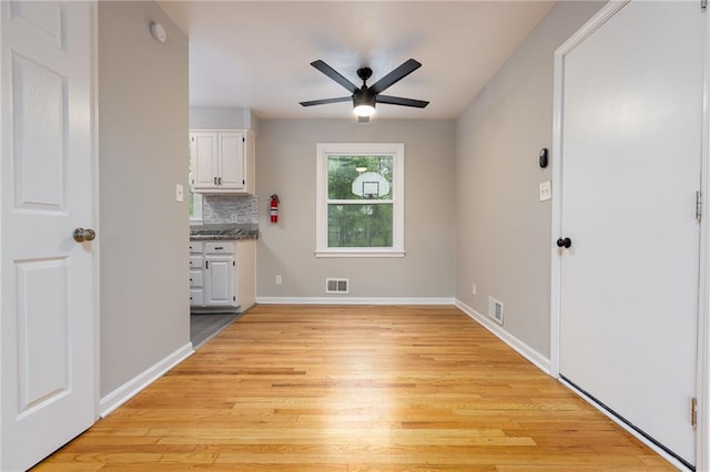 unfurnished dining area featuring a ceiling fan, light wood-style flooring, and visible vents