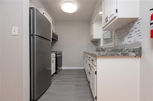 kitchen featuring white cabinets, tasteful backsplash, stainless steel appliances, baseboards, and light wood-type flooring