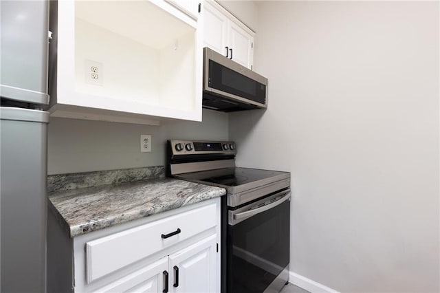 kitchen featuring white cabinets, light stone countertops, and stainless steel appliances
