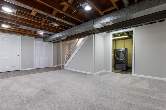 finished below grade area featuring carpet floors, stairs, baseboards, washer / dryer, and visible vents