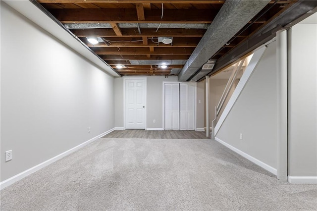 finished basement with carpet floors, baseboards, and stairway
