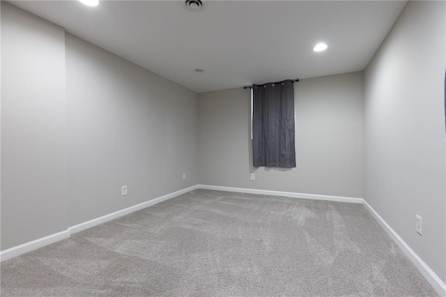 empty room featuring carpet floors, baseboards, recessed lighting, and visible vents