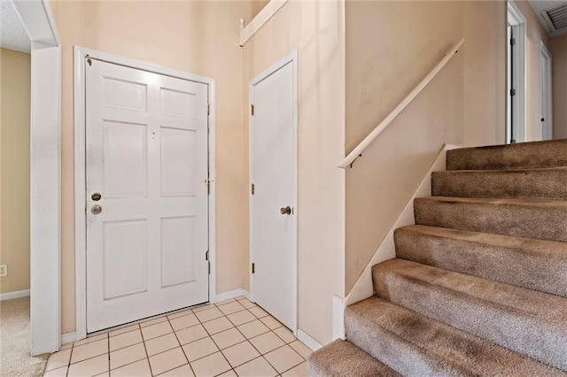 entryway featuring baseboards, stairs, light tile patterned floors, and visible vents
