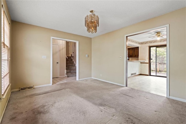 unfurnished room featuring visible vents, stairs, baseboards, and light carpet