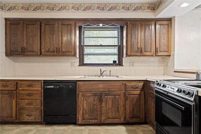 kitchen with a sink, tasteful backsplash, black appliances, and light countertops