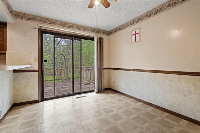 spare room featuring a textured ceiling, a ceiling fan, baseboards, light floors, and visible vents