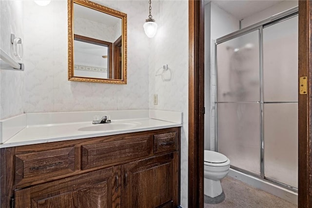 full bath featuring toilet, wallpapered walls, a shower stall, and vanity