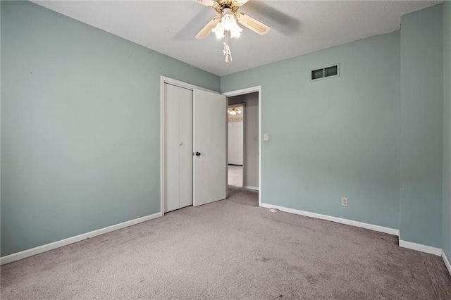 unfurnished bedroom featuring baseboards, visible vents, carpet, and a closet