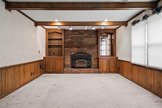 unfurnished living room with carpet flooring, wood walls, and a wainscoted wall