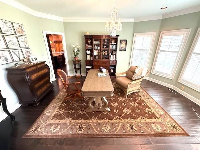 dining space featuring an inviting chandelier, ornamental molding, baseboards, and hardwood / wood-style floors