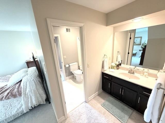 bathroom featuring vanity, baseboards, toilet, and visible vents