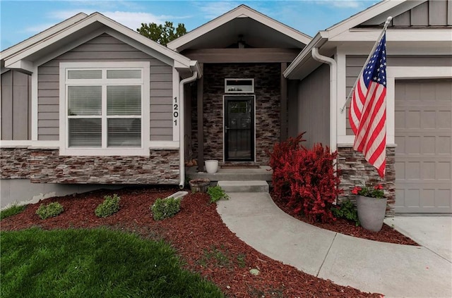 property entrance featuring board and batten siding, stone siding, and a garage
