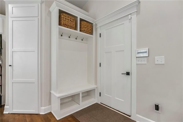 mudroom featuring baseboards and dark wood-style floors