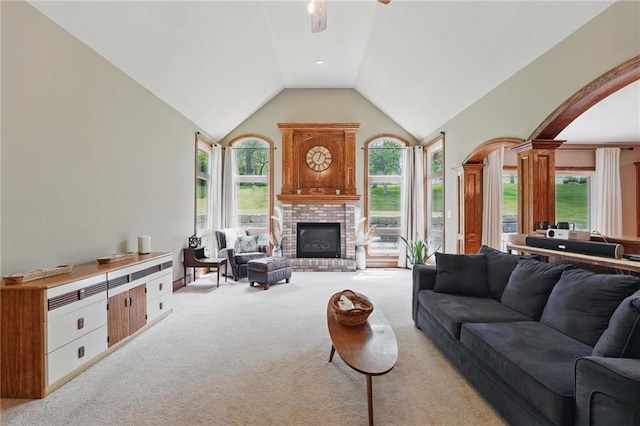 22721 E 27th Street Ct S, Blue Springs, MO 64015 - living area featuring arched walkways, ornate columns, light carpet, a brick fireplace, and lofted ceiling